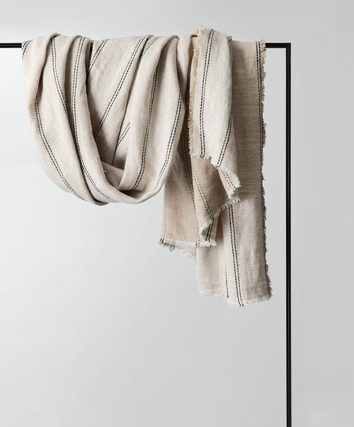 Mira Linen Throw - Ana draped natural European Flax™ linen with subtle black stripes, breathable sustainable luxury The beauty of home