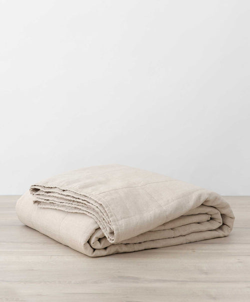 Quilted Bedcover - Natural folded on wood surface showcasing breathable soft linen The beauty of home
