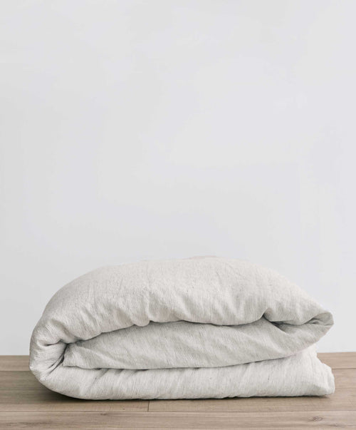 Bedroom Edit - White & Pinstripe folded on wood surface showcasing breathable, natural European Flax linen The beauty of home