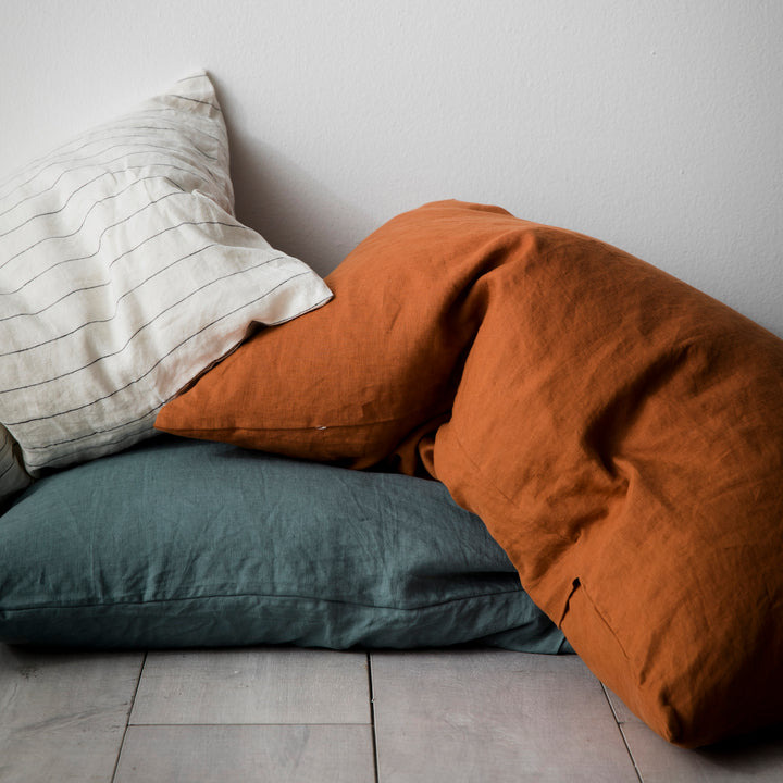 A trio of linen Pillowcases in Pencil Stripe, Cedar and Bluestone.