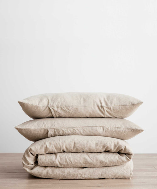 Linen Duvet Cover Set - Natural folded with matching pillowcases, highlighting soft breathable linen texture on wood surface