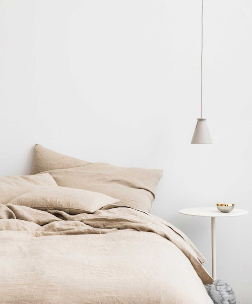 Natural linen duvet cover set on bed with soft pre-washed texture and mother of pearl button closure detail