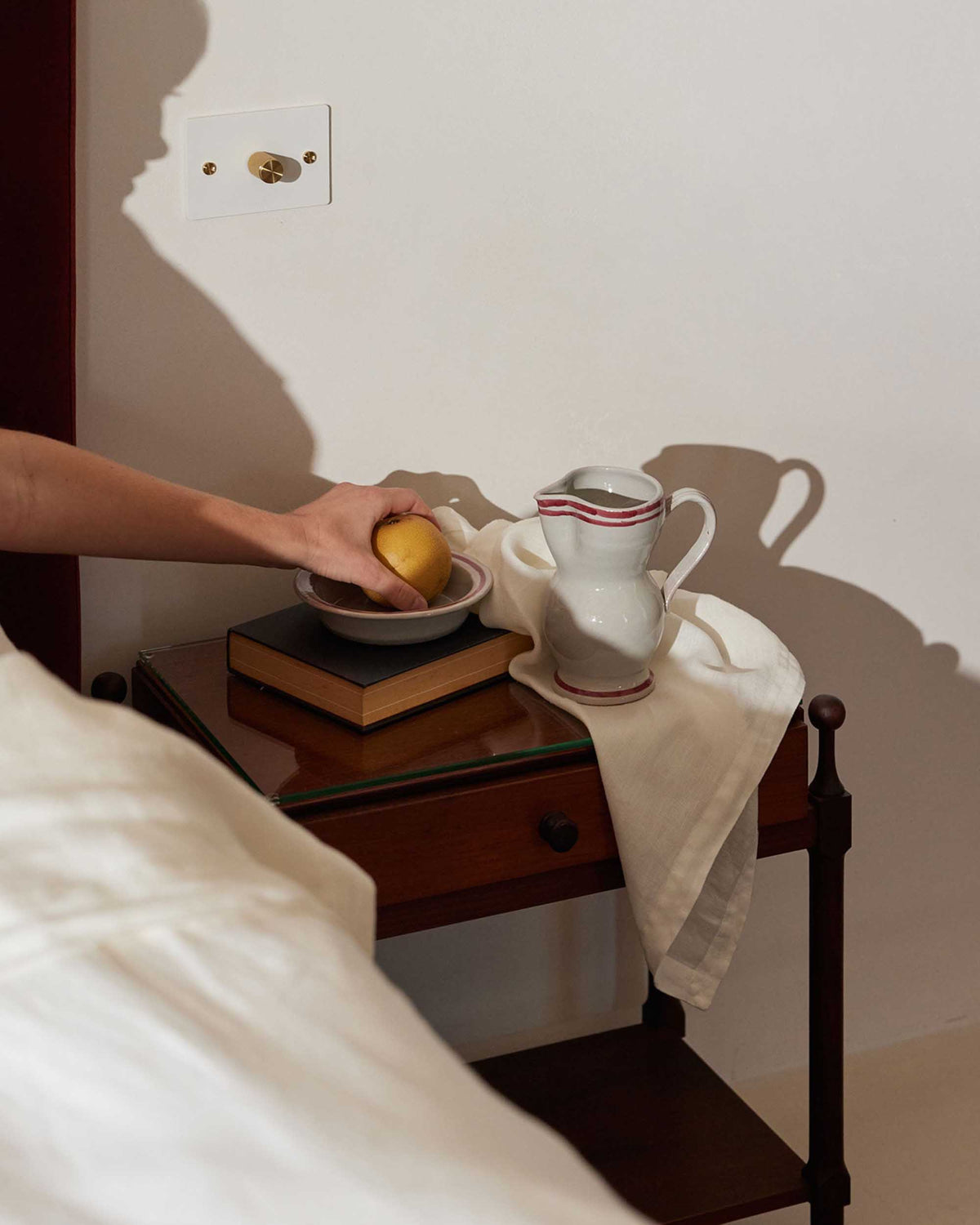 Linen Table Napkins - Ivory draped over a bedside table beside a vintage ceramic pitcher