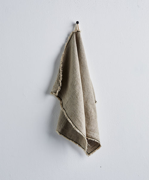Fia Kitchen Towel - Pine hanging with fringed edges and natural linen texture against soft white wall The beauty of home