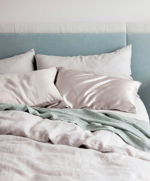 Linen Duvet Cover Set in smoke grey with soft pre-washed fabric and mother of pearl button closure on bed