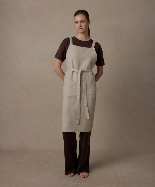 Jude Linen Apron in natural tone worn by model showing adjustable straps and heavyweight linen fabric texture