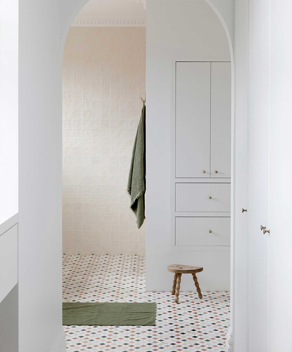 Bathroom Scene with Forest Green Towel Hanging and Bath Mat on the Floor