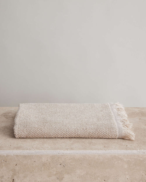 Pure Linen Bath Towel - Natural folded linen towel with fringed edge on stone surface