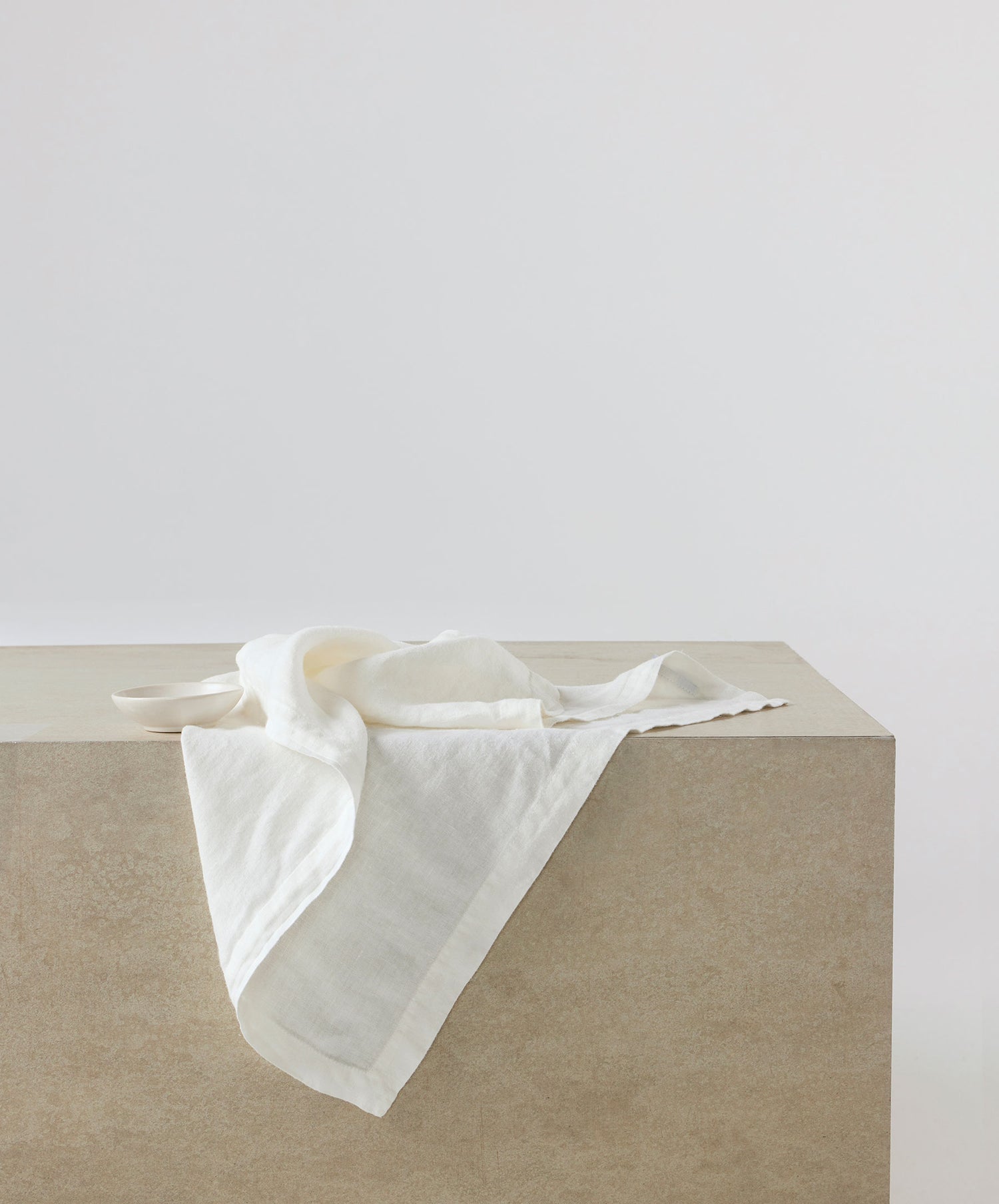 Linen Table Napkins - Ivory softly draped on smooth stone surface showcasing natural breathable fabric The beauty of home