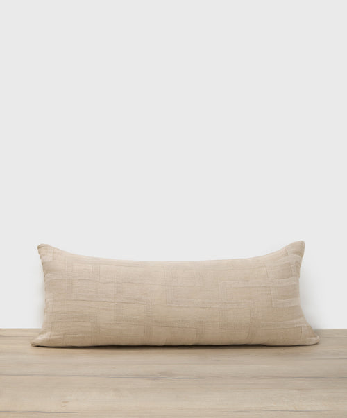 Beige pillow on a wooden surface with a white background