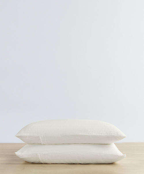 Set of 2 Linen Pillowcases - Ivory stacked on wooden surface with soft texture and natural breathable linen The beauty of home