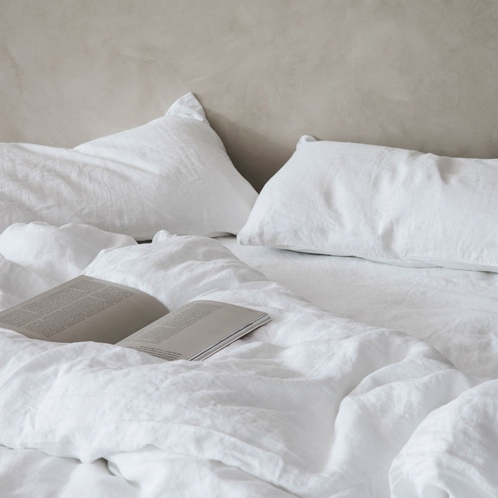 A bed dressed in White bed linen, styled with a book. Sizes: Single, Double, Queen, King