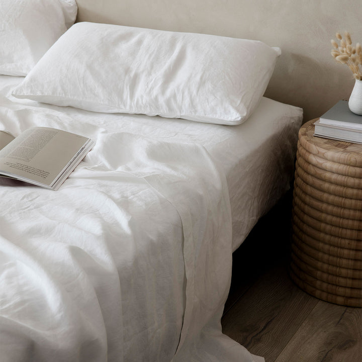 A bed dressed in a Linen Sheet Set with Pillowcases in White				
