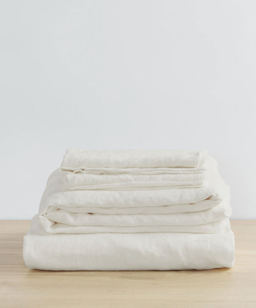 Linen Sheet Set with Pillowcases - Ivory folded neatly on wood surface with soft natural texture The beauty of home