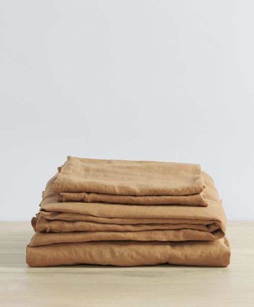 Linen Sheet Set with Pillowcases - Sand folded neatly on natural wood surface showcasing soft, breathable linen The beauty of home