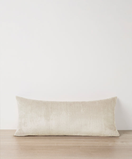 Talik Velvet Lumbar Cushion Cover - Cream resting on wood surface with soft texture and subtle sheen The beauty of home