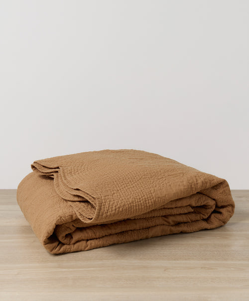 Willow Embroidered Quilt - Nutmeg folded on light wood surface, showcasing breathable European Flax™ linen The beauty of home