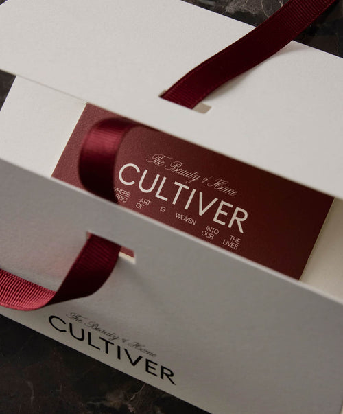 Cultiver packaging with a red ribbon on a dark surface