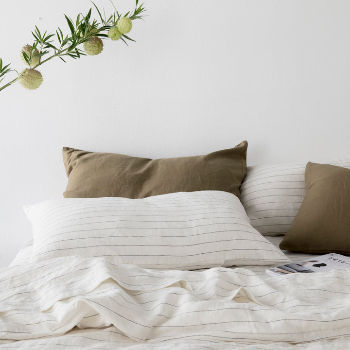 A bed dressed in Pencil Stripe and Olive bed linen