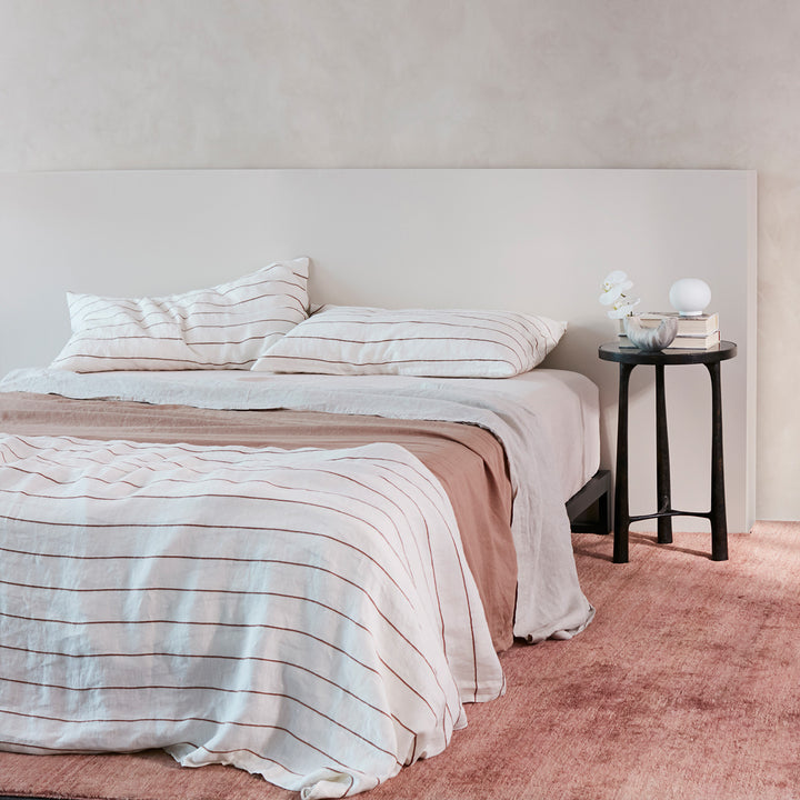  A bed dressed in Cedar Stripe, Fawn, Blush and Smoke Grey bed linen