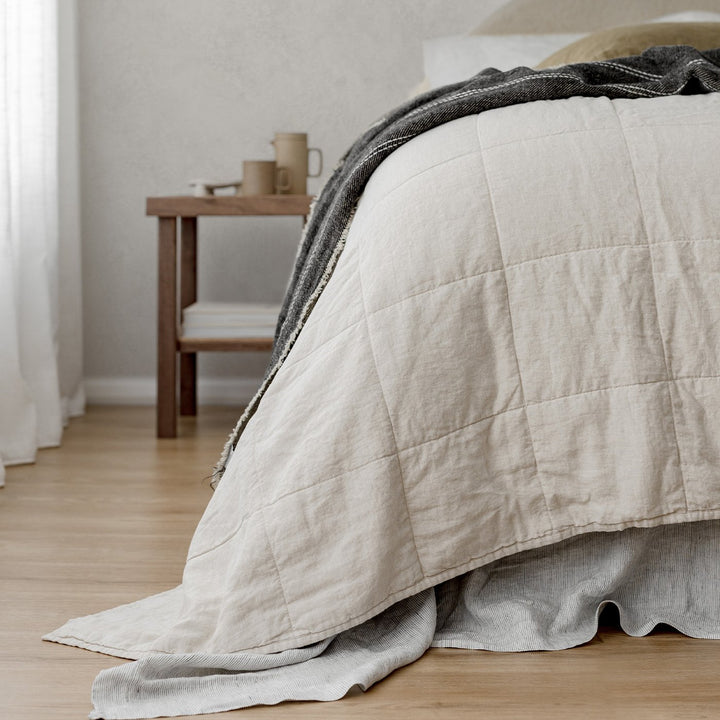 A Quilted Bedcover in Natural paired with Pinstripe and Olive bed linen, featuring a Mira Linen Throw in Rafa