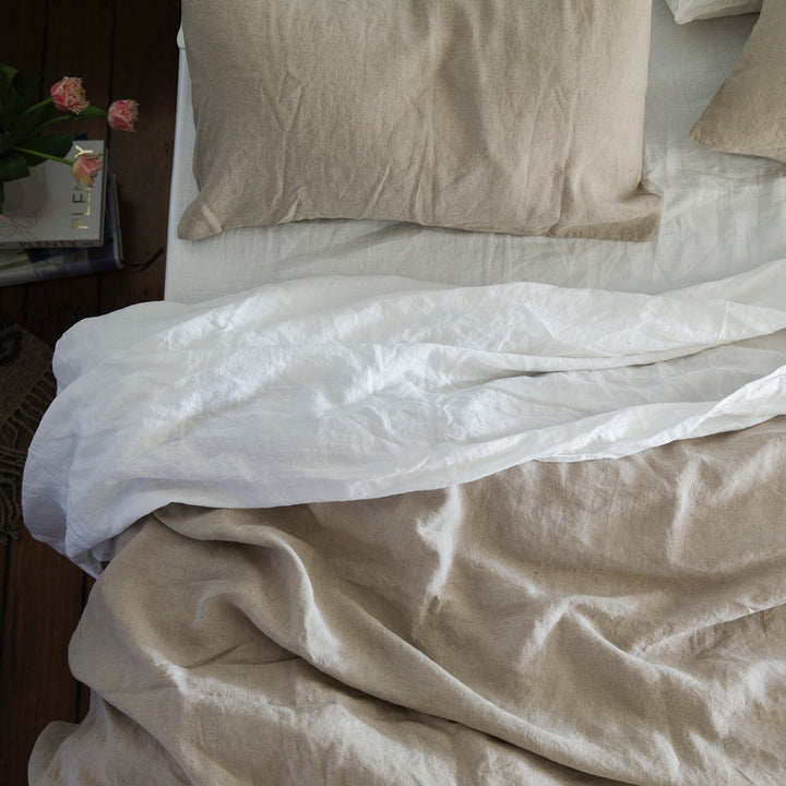 A bed dressed in White and Natural bedlinen.