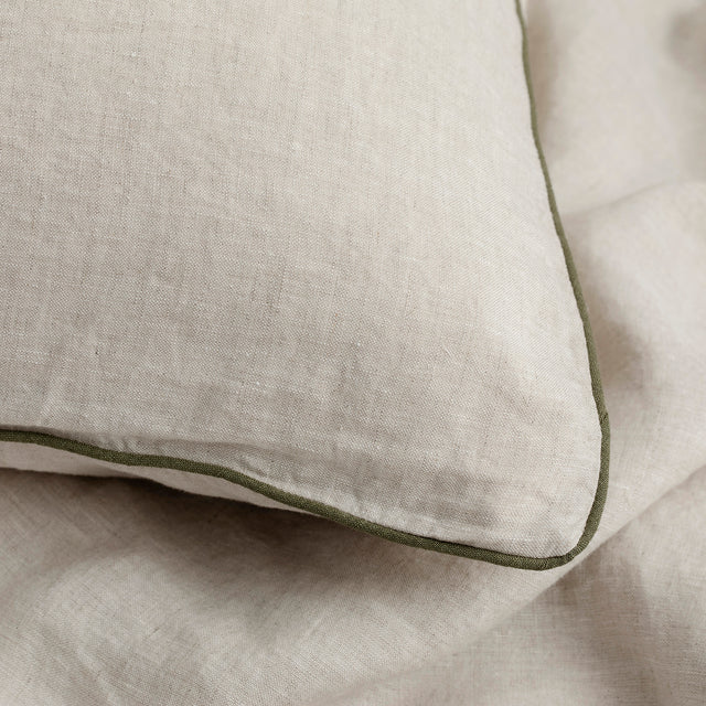A close up of a Piped Linen Euro Pillowcase in Natural and Forest