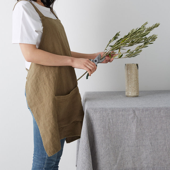 Model wears Jude Apron in olive colour